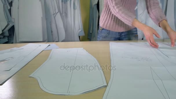 Um alfaiate prepara vários padrões de papel . — Vídeo de Stock