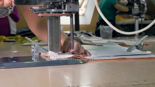 Two pieces of fabric clasped together under cutting knife. — Stock Video