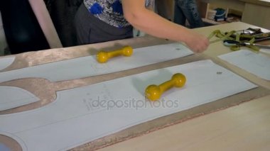 Bir terzi kağıt kalıpları kumaş üzerine aktarır..