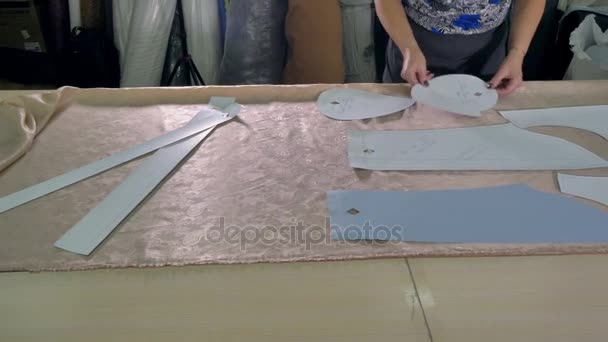 A tailor choosing pattern placement on cloth. — Stock Video