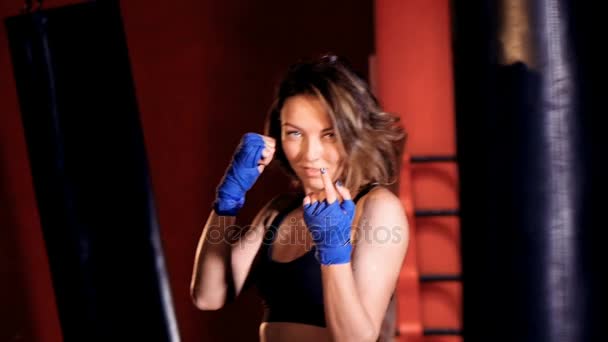 Mujer valiente haciendo señas con la mano en el estudio de boxeo . — Vídeo de stock