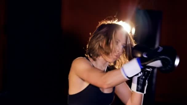 Close up van de vrouw boksen met bokszakken. — Stockvideo