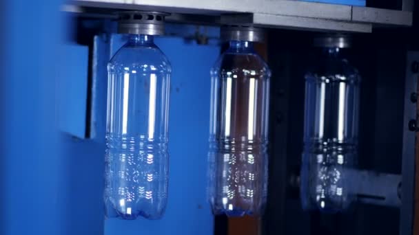 La botella de PET transparente preforma el movimiento lento con una luz brillante detrás de ellos. 4K . — Vídeos de Stock