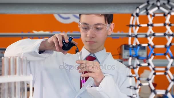 Um estudante mede e mistura produtos químicos . — Vídeo de Stock