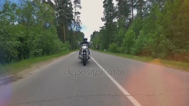 Motorcykel rids på tom väg i skogen. — Stockvideo