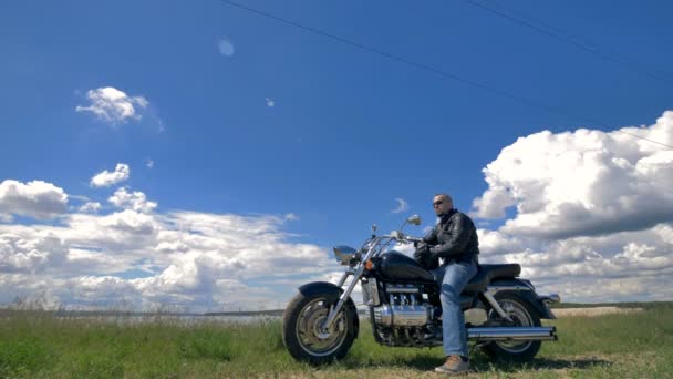 Modrou oblohu a bílé mraky, motorkář a jeho motocykl. — Stock video