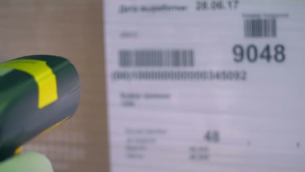 Een barcodescanner gebruikt op een kartonnen doos sticker. — Stockvideo