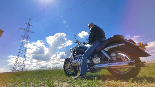 Un motociclista descansa en su motocicleta quieta . — Vídeos de Stock