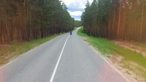 Un disparo aéreo de larga distancia sobre un motociclista que se aleja . — Vídeo de stock