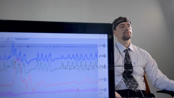 Um detector de mentiras em uma tela quando um homem responde a perguntas . — Vídeo de Stock