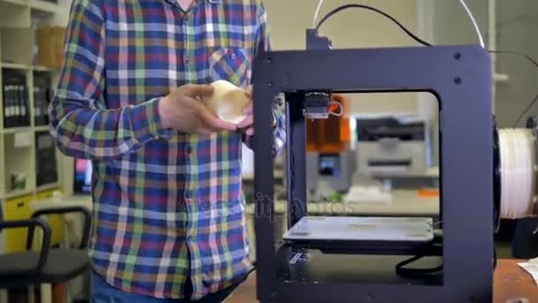 Um homem pega uma amostra acabada impressa em 3D . — Vídeo de Stock
