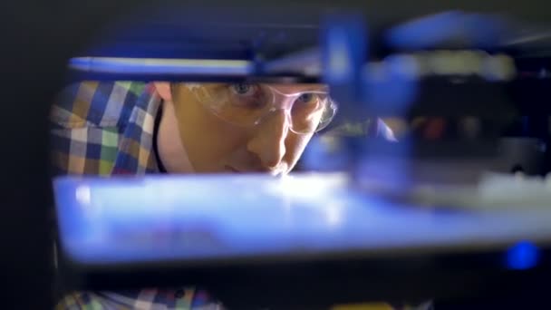 Ongerust ogen van een ingenieur die toezicht houdt op het proces van 3d-printing. — Stockvideo