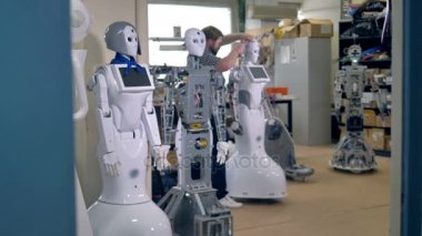 Bir çizgi uzun boylu robotlar onları tamir başlatmak meşgul bir tamirci bekliyor. 4k.