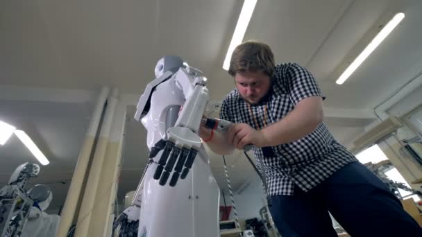 Ein schwacher Blick auf einen Mann, der Roboterkörper aus Kunststoff anbringt. — Stockvideo