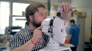 Bir teknisyen robotlar baş kabuk ortaya çıkarır..