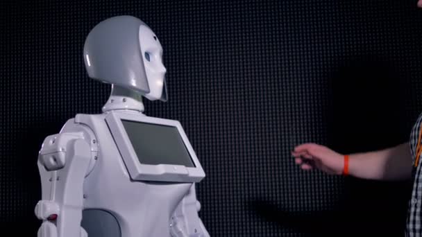 Un technicien gifle la main des robots féminins .