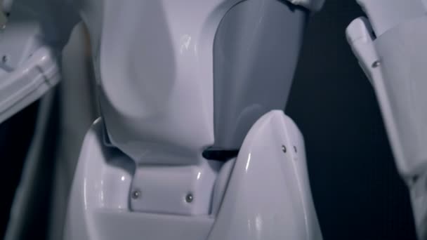 Een robot lage volgens het verhogen van zijn armen. — Stockvideo