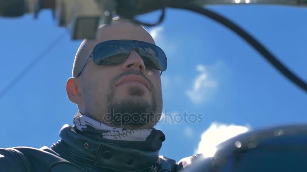 Αρσενικό μοτοσικλετιστή φορώντας γυαλιά ηλίου και δερμάτινο μπουφάν. — Αρχείο Βίντεο