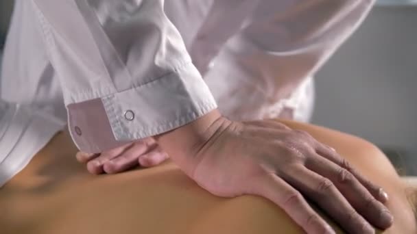 En manuell medicinsk massage på en kvinnlig rygg. — Stockvideo