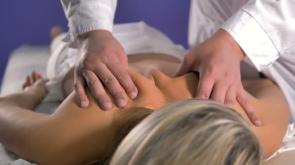 Le mani massaggiatrici professionali lavorano sulla parte superiore della schiena femminile . — Video Stock