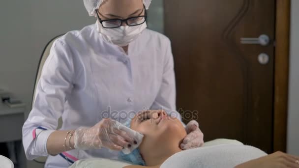 A beautician cleans clients face with a napkin. — Stock Video