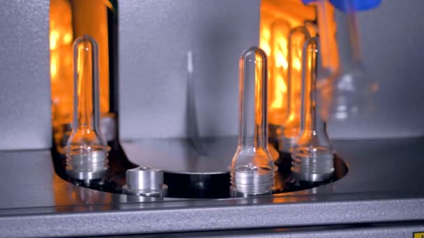 De productie van plastic flessen. Een fabriek werknemer installeert nieuwe Pet-preforms voor voorverwarming. — Stockvideo