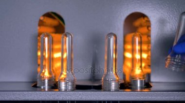 İşçi el preform önce ve sonra işlem ön ısıtma değiştirmek. Plastik şişe üretim.