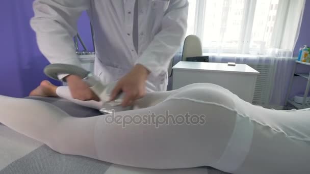 Een vrouw ligt voor een mechanische massage sessie. — Stockvideo