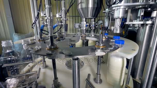 Vista lateral de una máquina automática de embotellado de leche . — Vídeo de stock