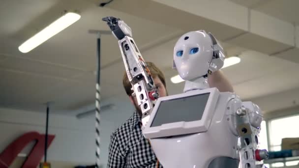Ingeniero que fija la cabeza de los robots con una herramienta . — Vídeo de stock