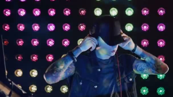 Un DJ à capuchon noir tremble au rythme .