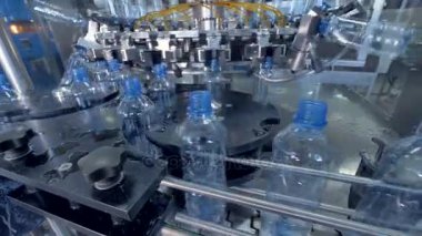 Ağır çekimde yıkama sonrası taburcu mavi plastik şişe.