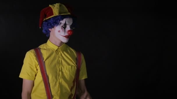 En clown jonglerar en trä yxa med ena handen. — Stockvideo