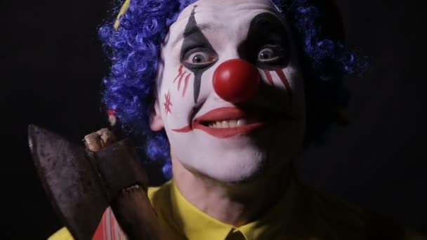 Клоун робить рухи розрізання обличчя сокирою . — стокове відео