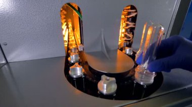 Bir çalışan yeni plastik preform boş yuva yükler..