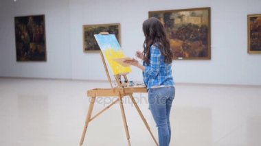 Kadın moda ressam resim şövale üzerinde çizim. 4k.