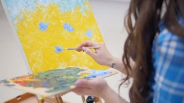 Kadın ressam bir beyaz kağıt üzerine yağlı boya ile resim. 4k.