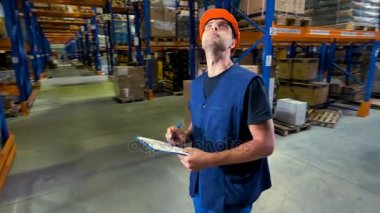 Bir depolama tesisinde bir genç ciddi ambar denetçisidir.