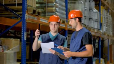 İki adam büyük bir ambarın içindeki yerleşimi iş sorunlarını tartışmak.