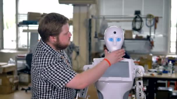 An engineer takes off a robots face panel. — Stock Video