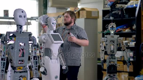 Inženýr nainstaluje kryt zpět hlavy na robota. — Stock video