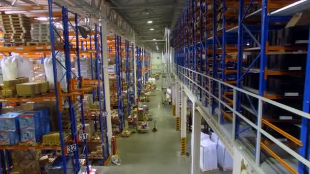 Caméra va entre les étagères d'entrepôt dans un entrepôt moderne avec de nombreux rayonnages, étagères. Aérien . — Video