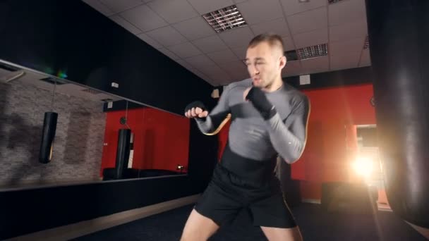 Silný muž bojovník způsobuje shadowboxing. — Stock video