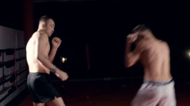 İki adam bir loş boks stüdyoda boks maçı.
