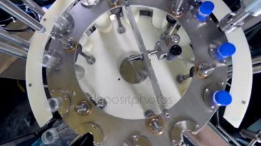 Yukarıdan bir dairesel süt şişe dolum istasyonu.