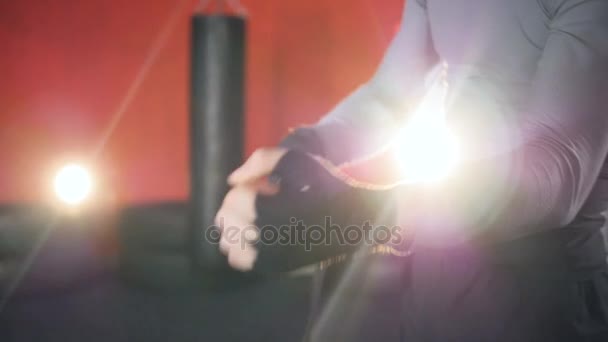Человек заклеивает свои руки чёрным боксёрским обертыванием . — стоковое видео