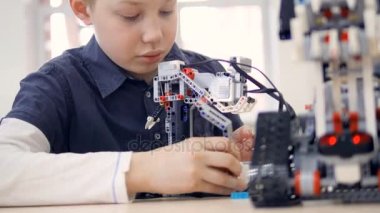 Robot ile oynayan genç çocuk mühendis. Yakın çekim.