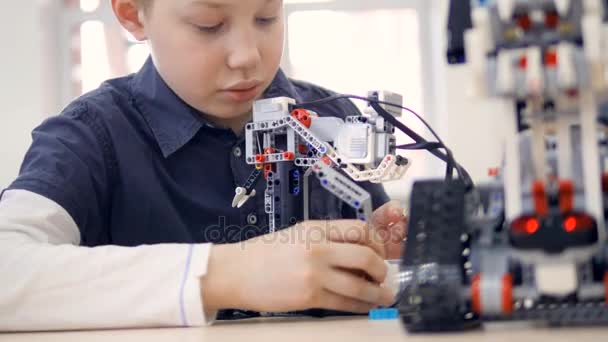 Ung pojke ingenjör spelar med robot. Närbild. — Stockvideo