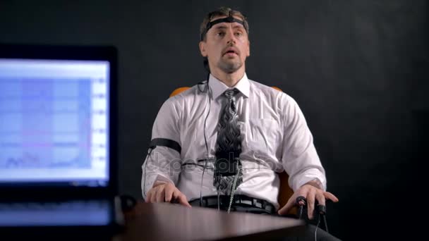 A man deeply breathing close to a polygraph data screen. — Stock Video