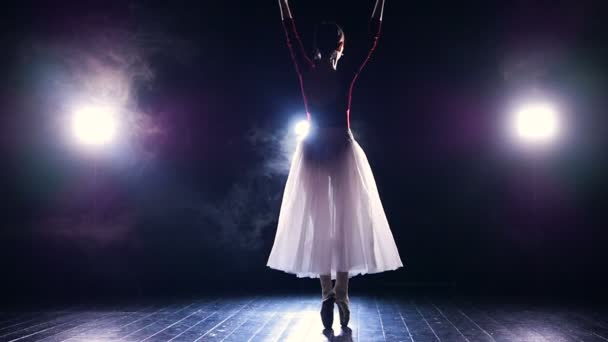 Una bailarina equilibra y gira en la oscuridad . — Vídeos de Stock